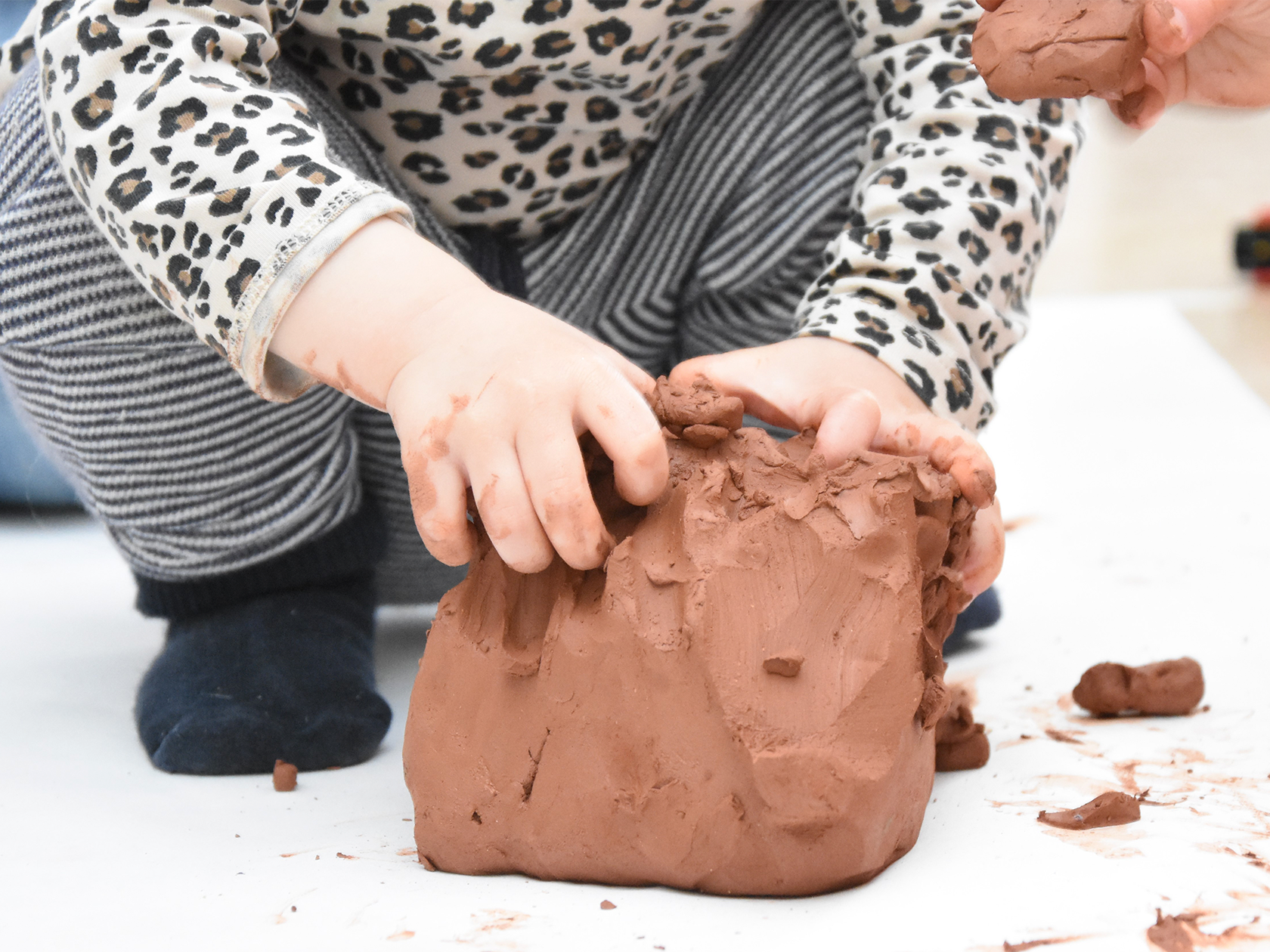 Förskolebarn som leker med lera