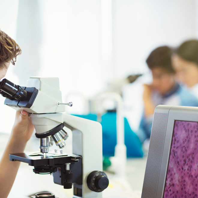 Elev använder mikroskop