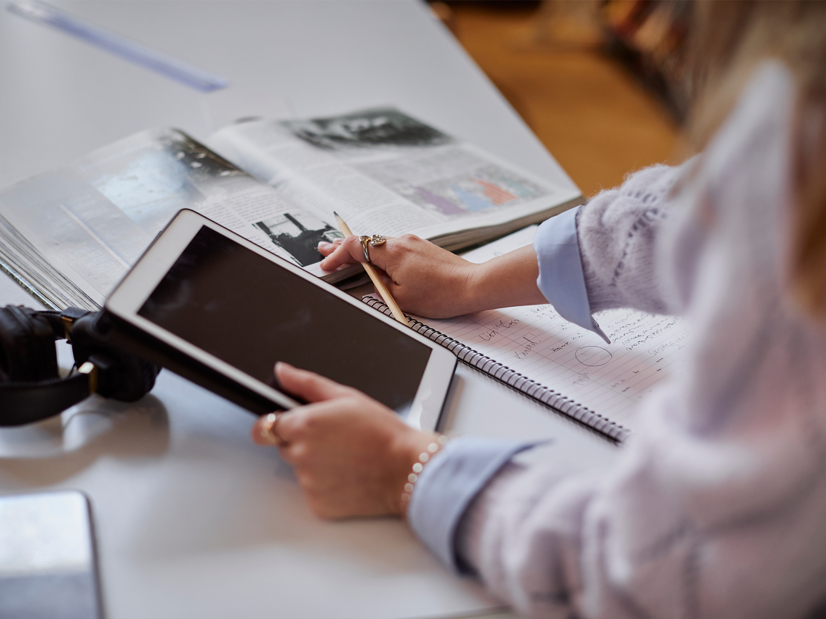 En person jobbar på Ipad och med AI