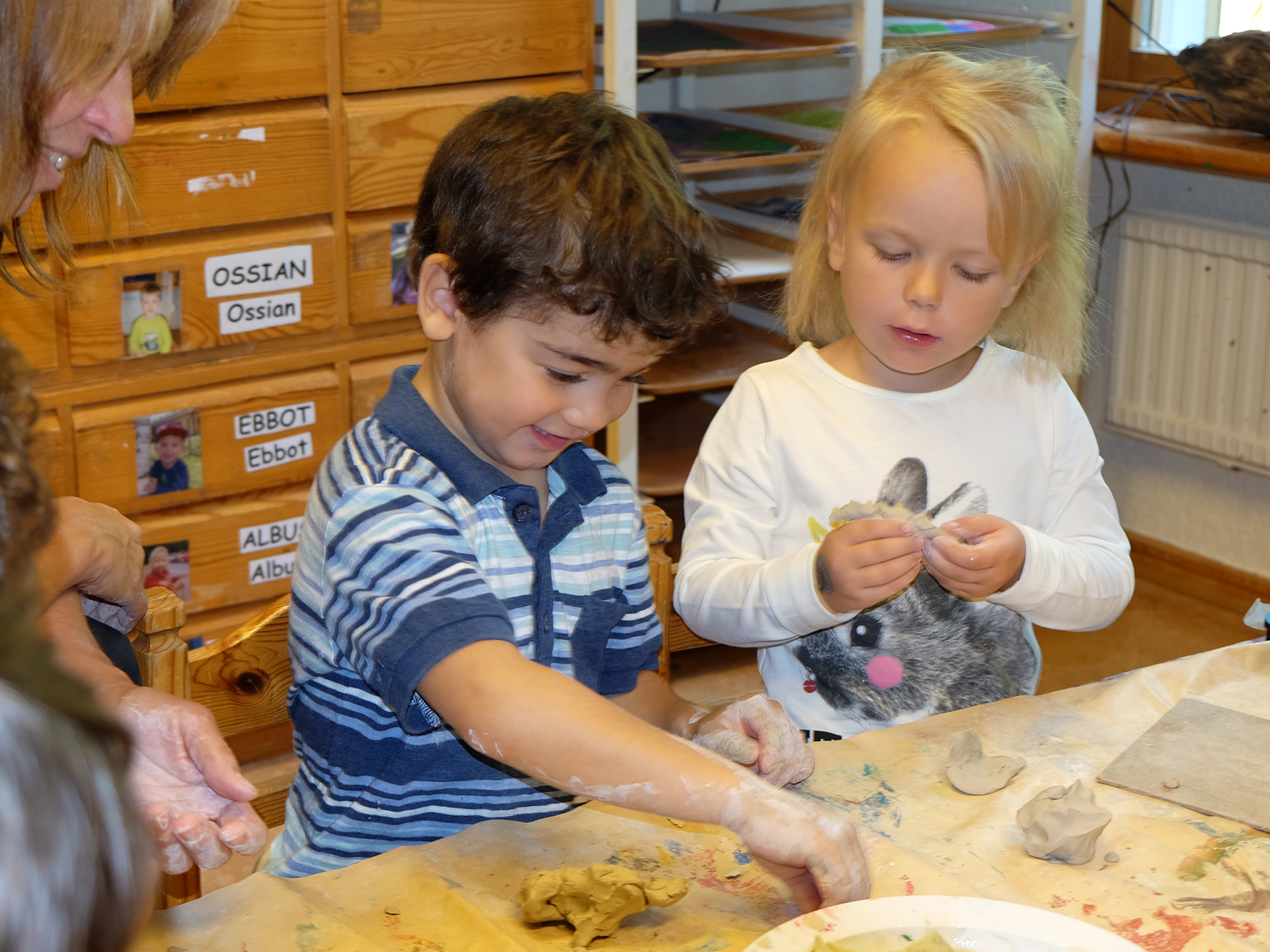 Förskolebarn som leker med lera